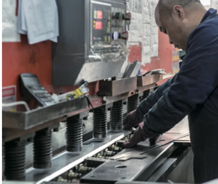 Operator running a CNC press brake to bend a rack profile